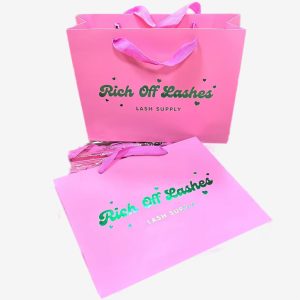 Bright pink laminated paper bag with metallic foil logo and cotton rope handles